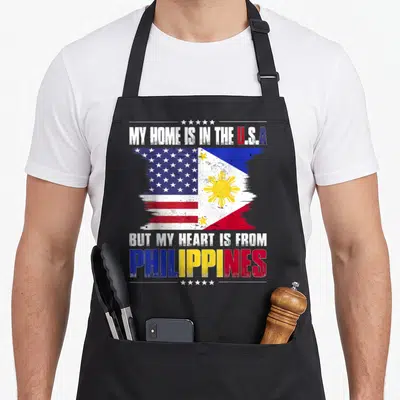 Grown patriots apron - Distressed split US and Philippine flags with stacked patriotic text — shown on a black cotton canvas apron against a white background