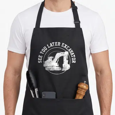 Later backhoe apron - White distressed excavator inside circle with arched text See You Later Excavator — shown on a black cotton canvas apron against a white background