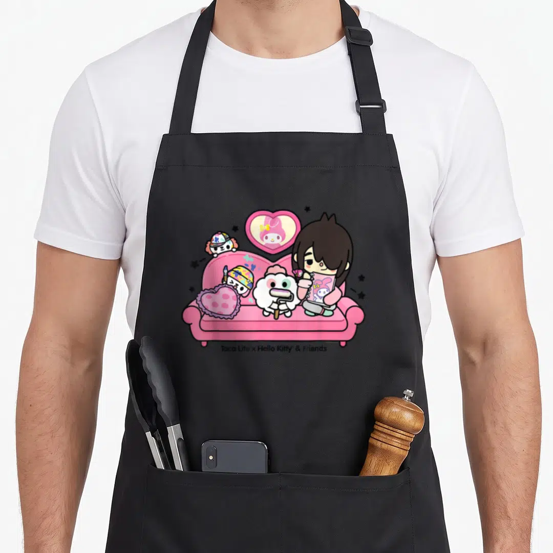 Toca friends apron - Character on pink sofa with cats, heart pillow, and bunny in heart frame — shown on a black cotton canvas apron against a white background