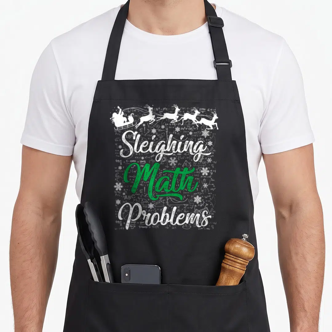 Sleighing xmas apron - Sleiving Math Problems text with Santa sleigh and math formulas — shown on a black cotton canvas apron against a white background