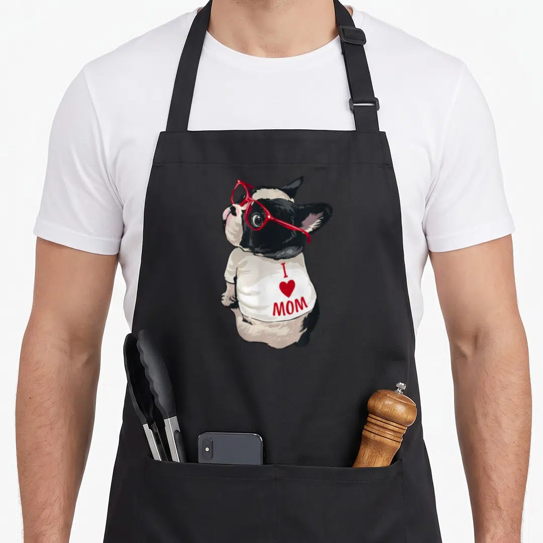 Vintage french bulldog apron - Cartoon dog in red glasses and white shirt with I Heart Mom text — shown on a black cotton canvas apron against a white background