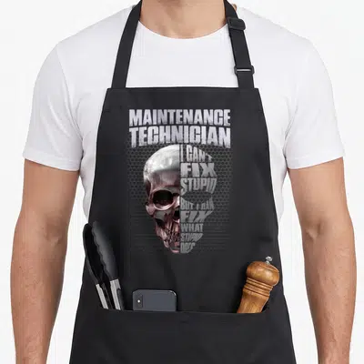 Maintenance stupid aprons - Realistic skull graphic with stacked text MAINTENANCE TECHNICIAN I CAN'T FIX STUPID — shown on a black cotton canvas apron against a white background