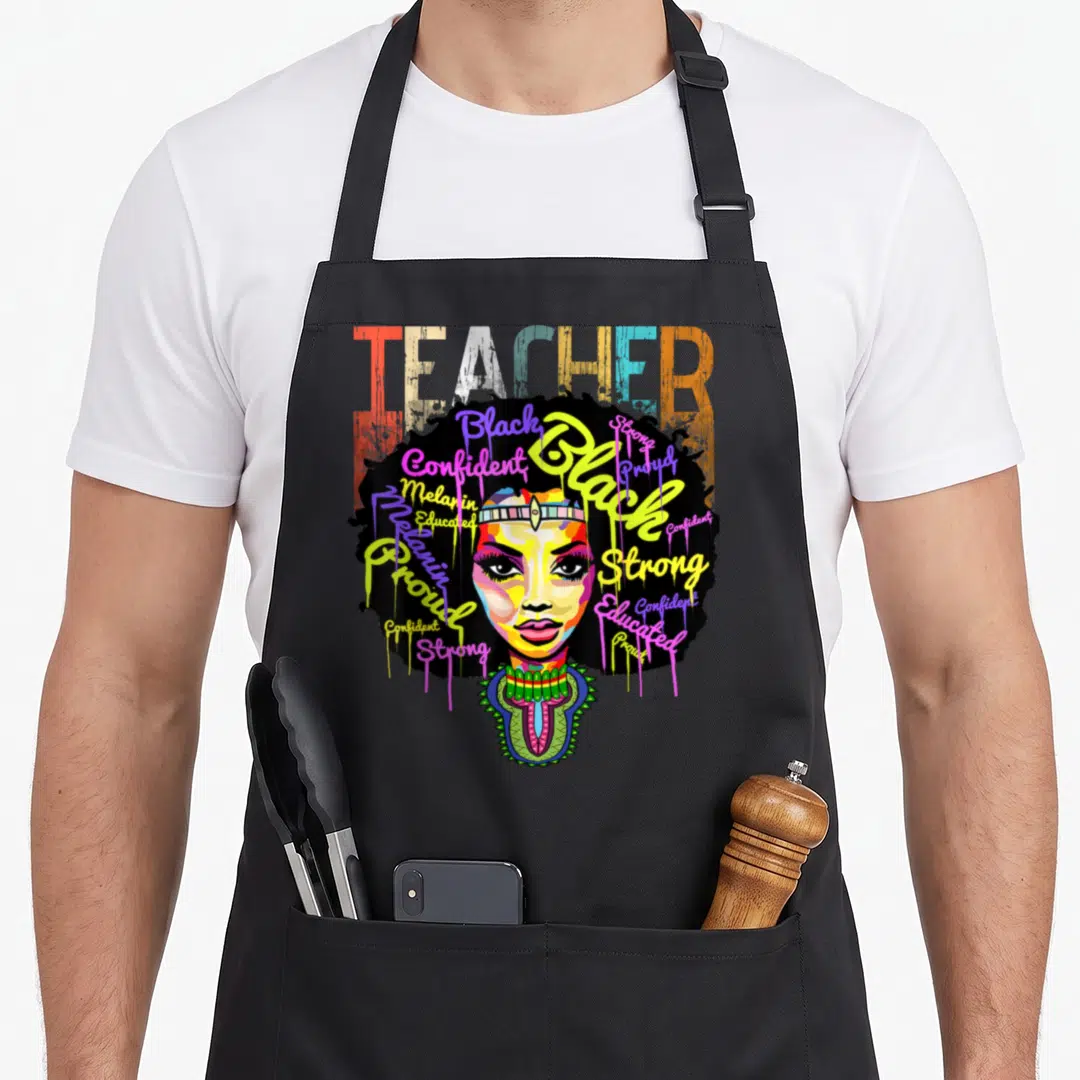 Teacher african apron - Cartoon woman face with colorful script words Black Proud Strong Melanin in afro hair — shown on a black cotton canvas apron against a white background