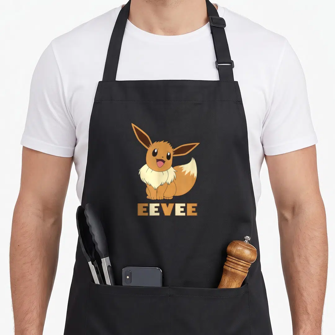Funny eevee apron - Cartoon Eevee sitting in brown and cream with EEVEE text below — shown on a black cotton canvas apron against a white background