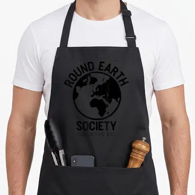 Even science apron - Black and white globe with arched text ROUND EARTH SOCIETY -CIRCA 500 B.C- — shown on a black cotton canvas apron against a white background