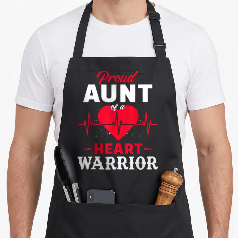 Aunt warrior chd congenital heart defect apron - Red heart with heartbeat line and Proud AUNT of a HEART WARRIOR text — shown on a black cotton canvas apron against a white background