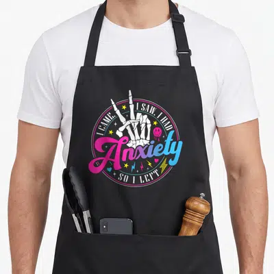 Came anxiety awareness apron - Skeleton hand peace sign pink blue gradient circle I came I saw I had anxiety so I left — shown on a black cotton canvas apron against a white background
