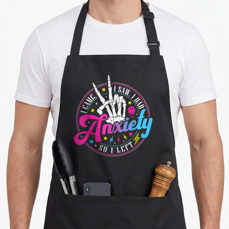 Came anxiety awareness apron - Skeleton hand peace sign pink blue gradient circle I came I saw I had anxiety so I left — shown on a black cotton canvas apron against a white background