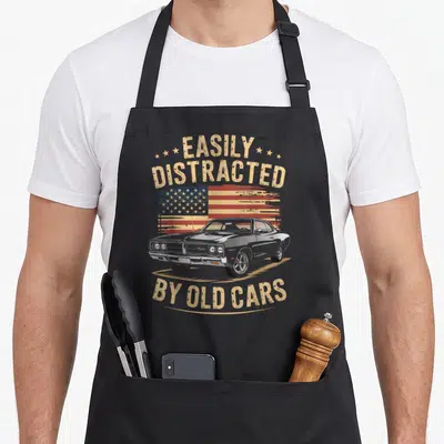 Easily car apron - Grey classic car over distressed red white and blue flag with arched tan text reading Easily — shown on a black cotton canvas apron against a white background