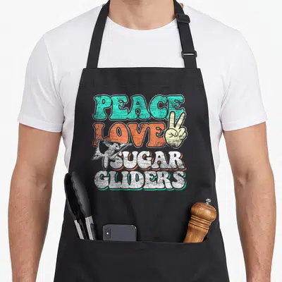 Frieden bags and aprons - Retro text PEACE LOVE SUGAR GLIDERS with peace sign hand and gliding sugar glider in teal — shown on a black cotton canvas apron against a white background