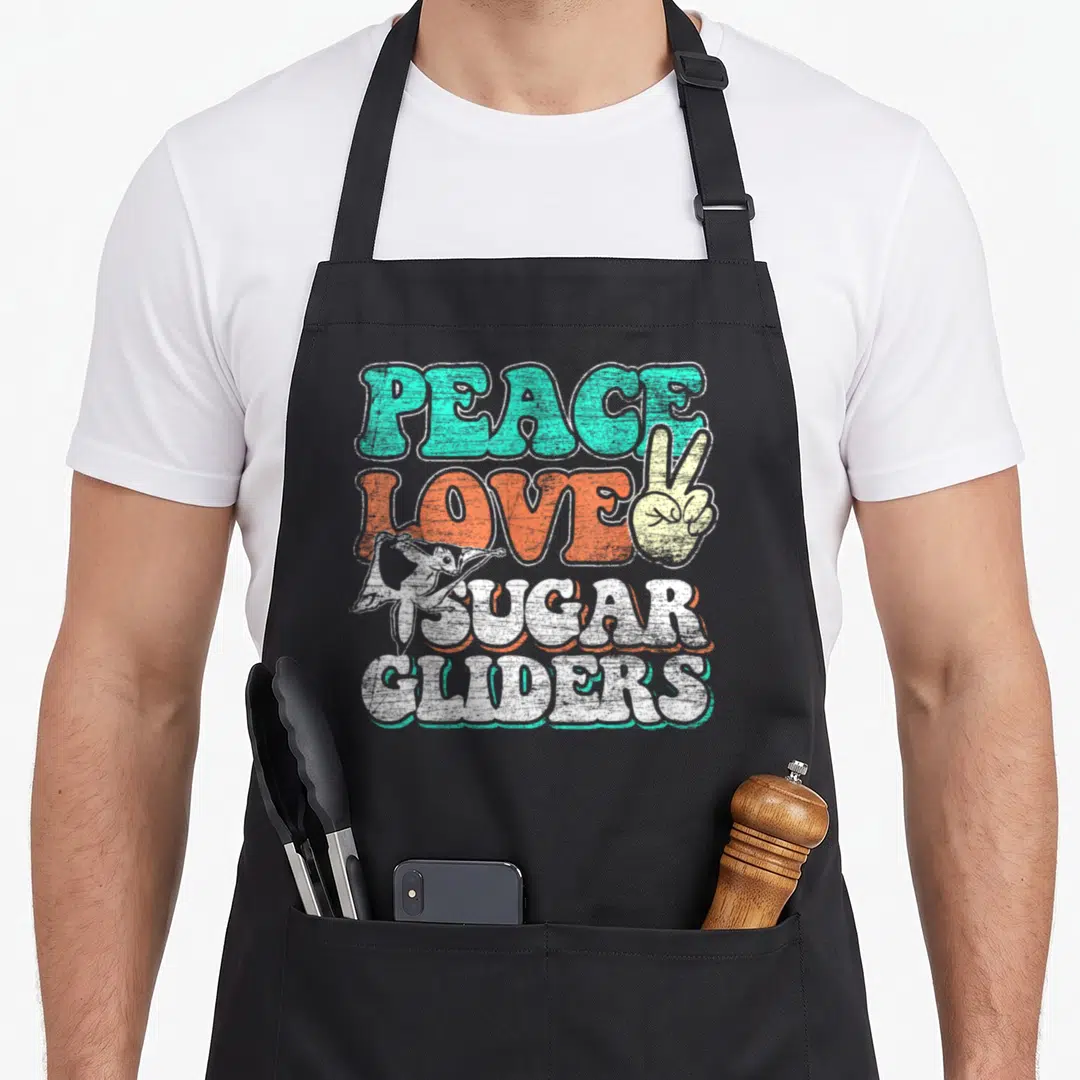 Frieden bags and aprons - Retro text PEACE LOVE SUGAR GLIDERS with peace sign hand and gliding sugar glider in teal — shown on a black cotton canvas apron against a white background