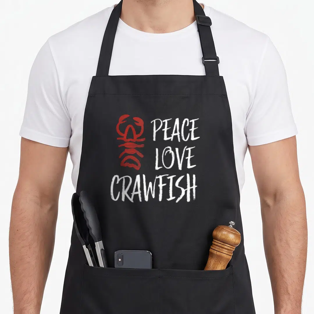 Peace crawfish boil apron - Red distressed crawfish graphic next to stacked white peace love crawfish text — shown on a black cotton canvas apron against a white background