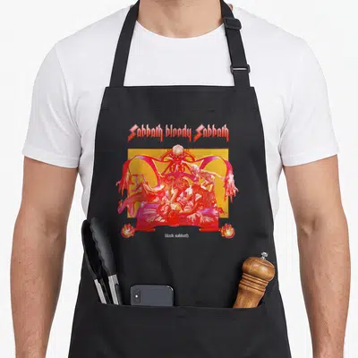Sabbath bloody apron - Sabbath bloody Sabbath text with red hands, skulls, and figures on a bed — shown on a black cotton canvas apron against a white background
