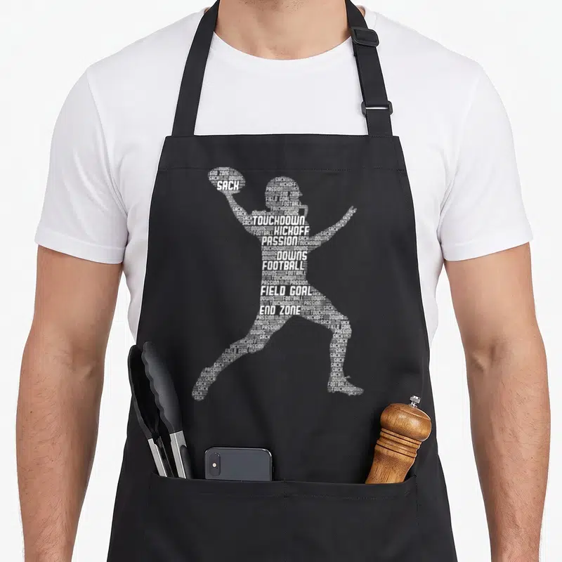 Player football apron for women - White word cloud forming football player silhouette using terms like sack — shown on a black cotton canvas apron against a white background