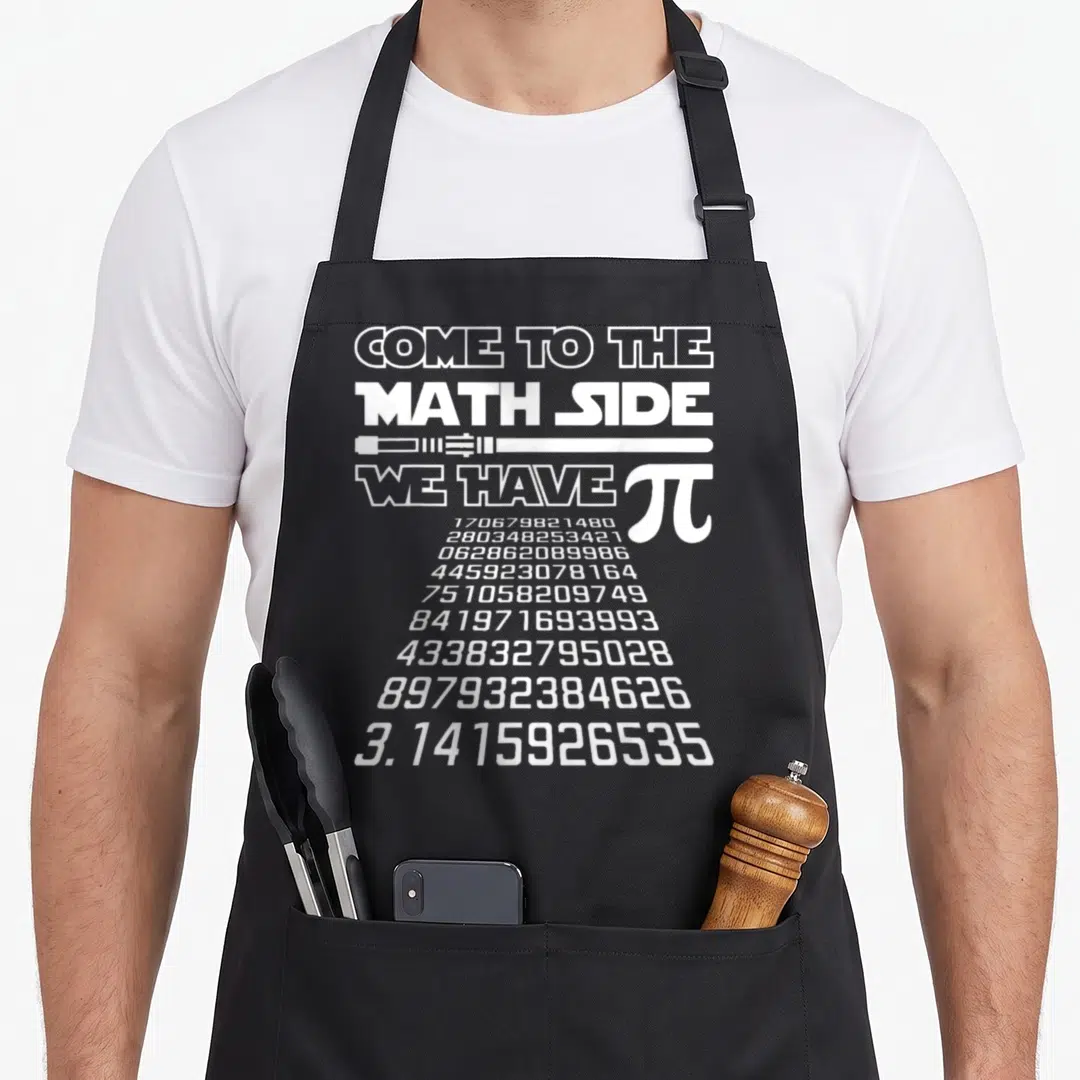 Come pie apron - White text COME TO THE MATH SIDE WE HAVE PI with lightsaber and digit column — shown on a black cotton canvas apron against a white background