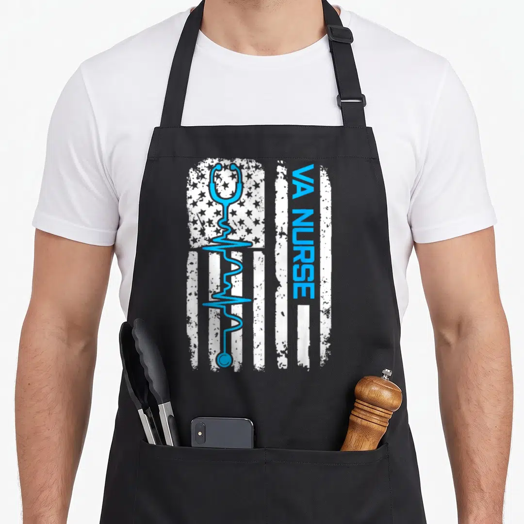 Flag nurse nursing apron - Distressed white US flag with light blue stethoscope and vertical VA NURSE text — shown on a black cotton canvas apron against a white background
