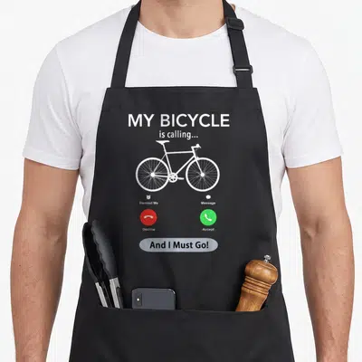 Calling bicycle apron - White bicycle on grey background with red and green call buttons and text My Bicycle is calling — shown on a black cotton canvas apron against a white background