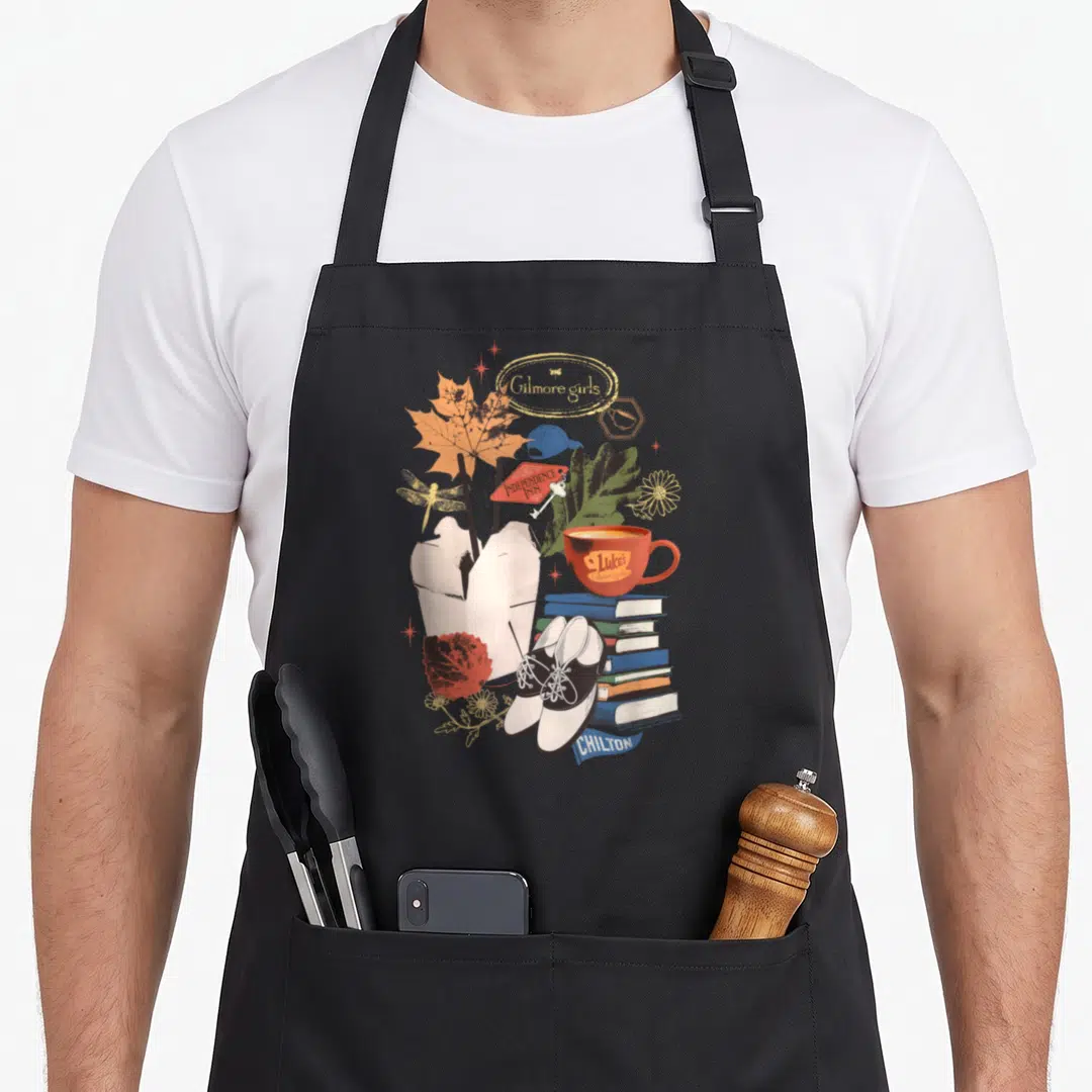 Collage gilmore girls apron - Red coffee cup, books, Chilton shoes, Independence Inn sign, and maple leaf in watercolor — shown on a black cotton canvas apron against a white background