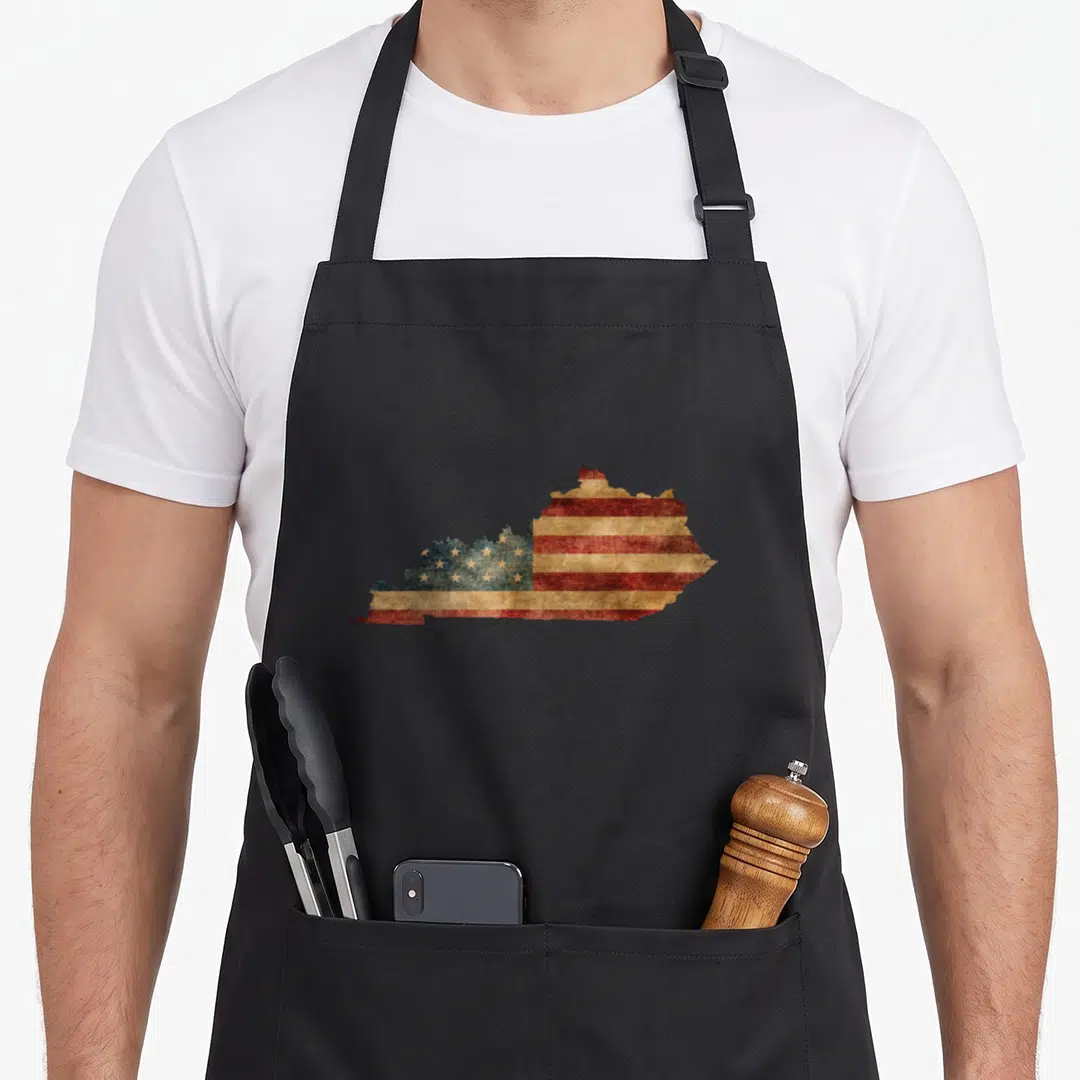 Kentucky patriotic apron - Distressed red white and blue American flag pattern filling a Kentucky state map silhouette — shown on a black cotton canvas apron against a white background