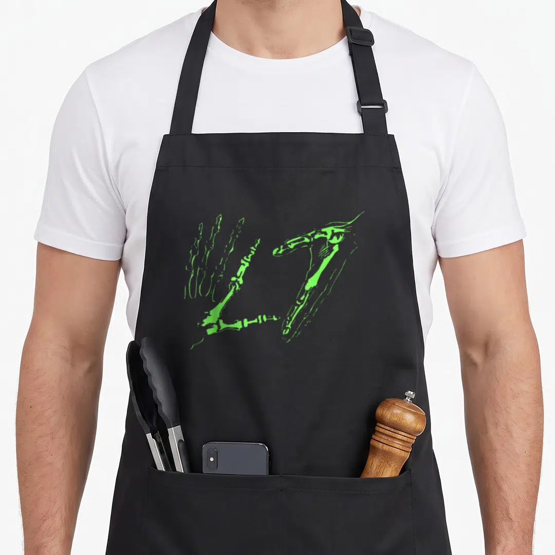Funny hand skeleton apron - Two lime green skeletal hands in line art forming a heart shape on black fabric — shown on a black cotton canvas apron against a white background