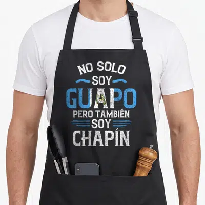 Solo guatemalan aprons - Stacked white and blue text NO SOLO SOY GUAPO PERO TAMBIEN SOY CHAPIN with flag-colored — shown on a black cotton canvas apron against a white background