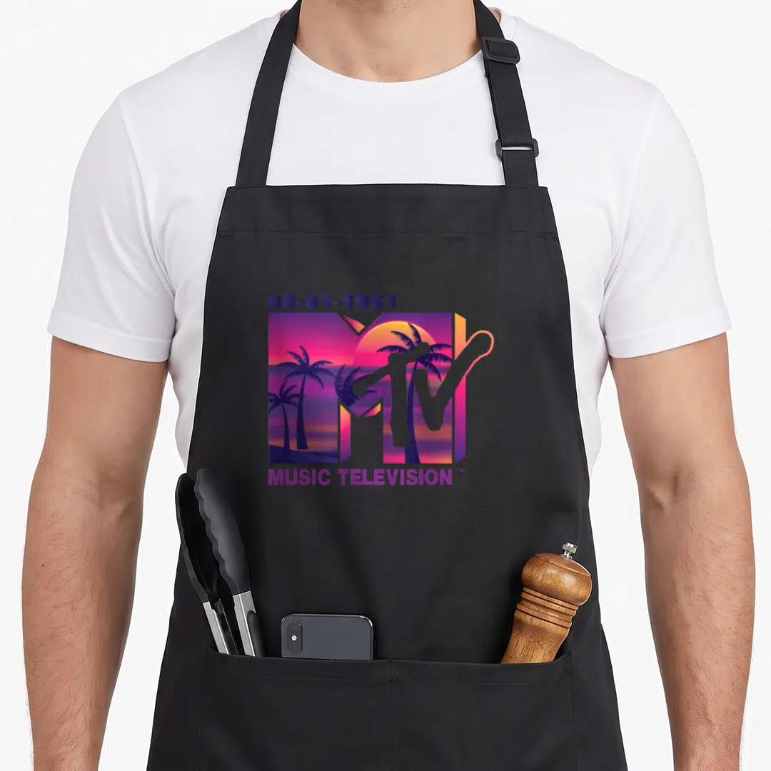 Palm mtv apron - 1981 MTV logo with sunset palm trees inside the M and MUSIC TELEVISION text below — shown on a black cotton canvas apron against a white background