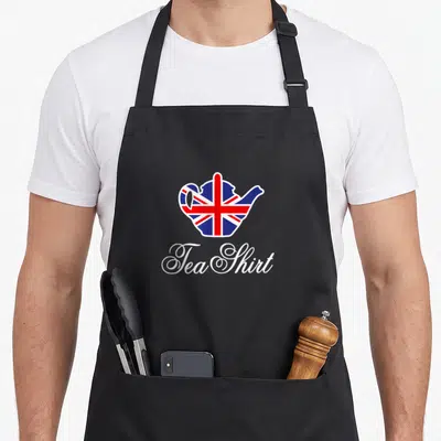 Union tea apron - Teapot filled with Union Jack pattern above white script reading Tea Shirt — shown on a black cotton canvas apron against a white background