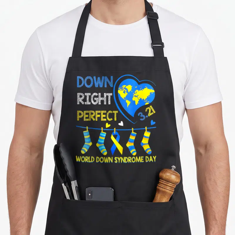 Right down syndrome awareness apron - Blue heart with yellow world map, stacked text, and four striped socks — shown on a black cotton canvas apron against a white background