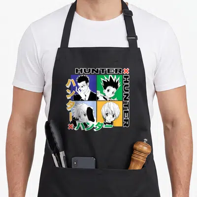 Grid hunter apron - Four anime character portraits in blue, green, yellow, and orange squares with HUNTERX text — shown on a black cotton canvas apron against a white background