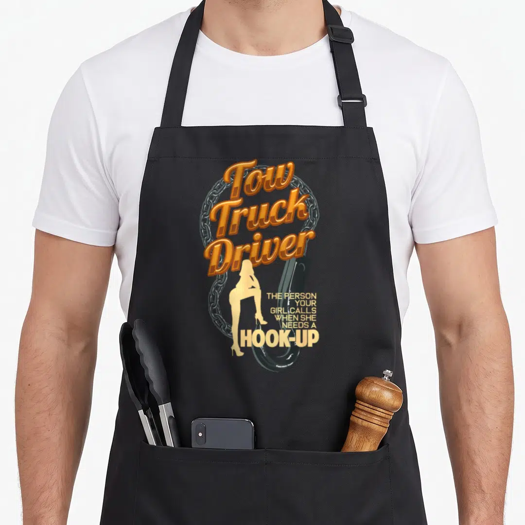 Trucking operator truck apron - Tow Truck Driver text with silver chain, black hook, and woman silhouette — shown on a black cotton canvas apron against a white background