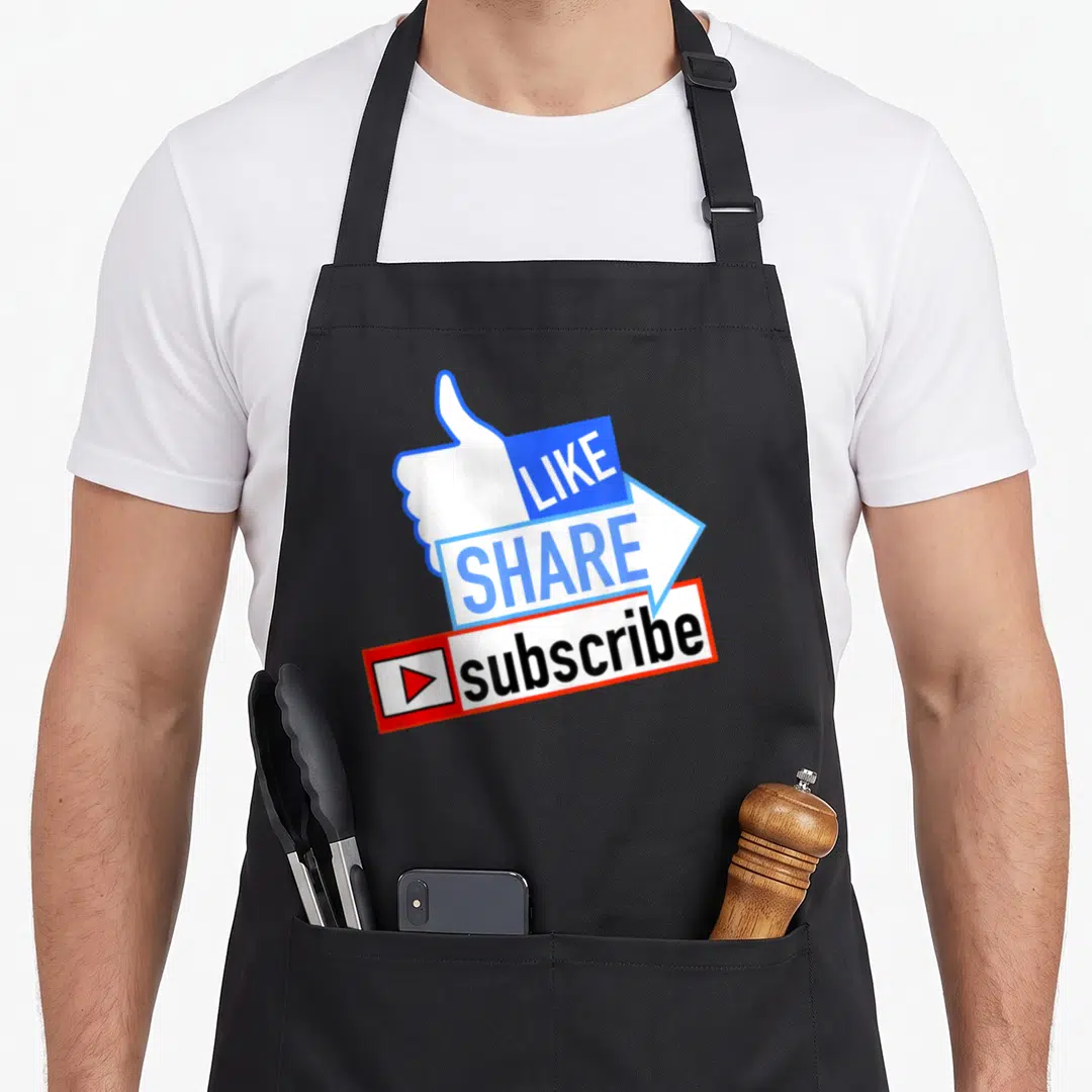 Social youtuber apron - Stacked thumbs up like arrow share and red subscribe play button icon in blue white and red — shown on a black cotton canvas apron against a white background