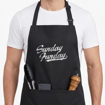Funday sunday apron - Stacked white vintage script text reading Sunday Funday with distressed texture — shown on a black cotton canvas apron against a white background