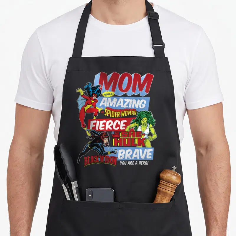 Funny amazing aprons - Retro comic art Mom Spider-Woman She-Hulk Black Widow text red blue green yellow — shown on a black cotton canvas apron against a white background