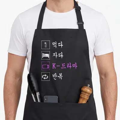 Eat korean apron - Four rows of Korean text and icons including a purple TV symbol — shown on a black cotton canvas apron against a white background