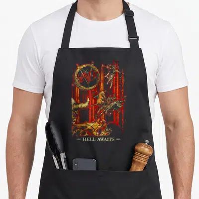 Hell slayer apron - SLAYER in gold pentagram, demonic scene, red streaks, 1985 HELL AWAITS 2020 text — shown on a black cotton canvas apron against a white background