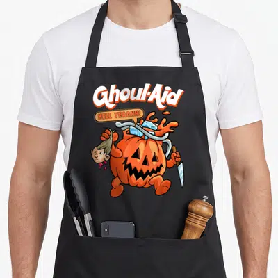 Ghoul halloween kitchen aprons - Cartoon pumpkin monster holding severed head and knife with Ghoul-Aid text — shown on a black cotton canvas apron against a white background