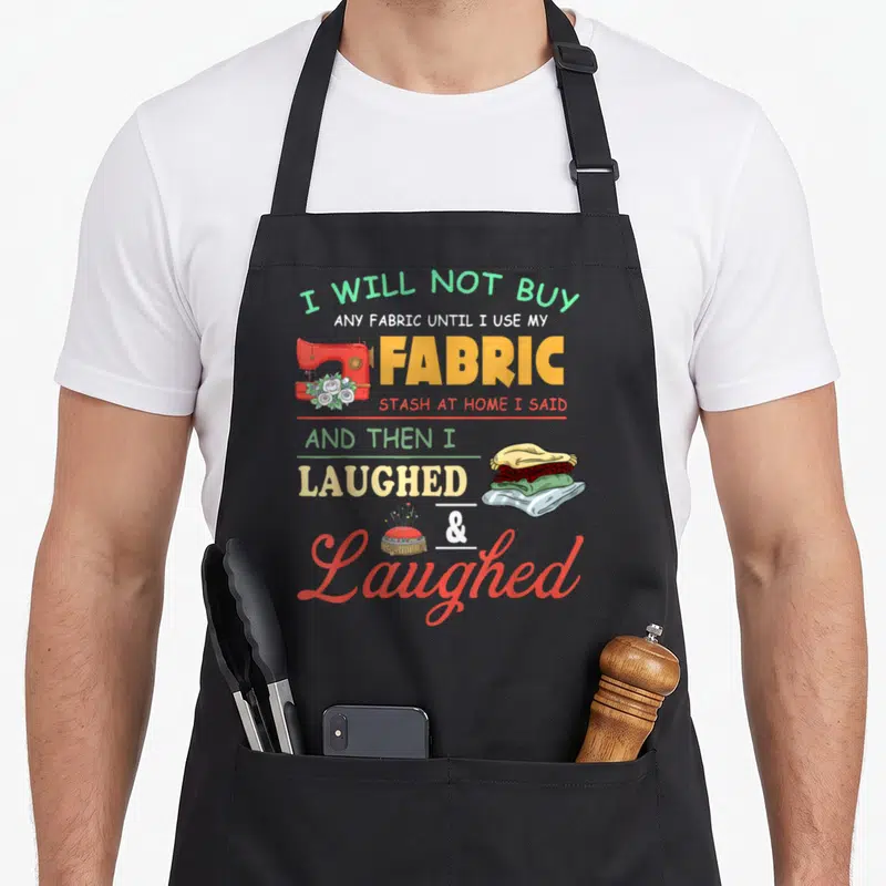 Sewer quilter apron - Red sewing machine and fabric stack with sarcastic stash quote text — shown on a black cotton canvas apron against a white background