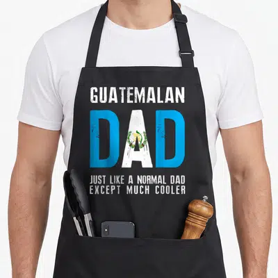 Normal guatemalan aprons - Guatemalan Dad text with flag fill in blue white green and distressed finish — shown on a black cotton canvas apron against a white background
