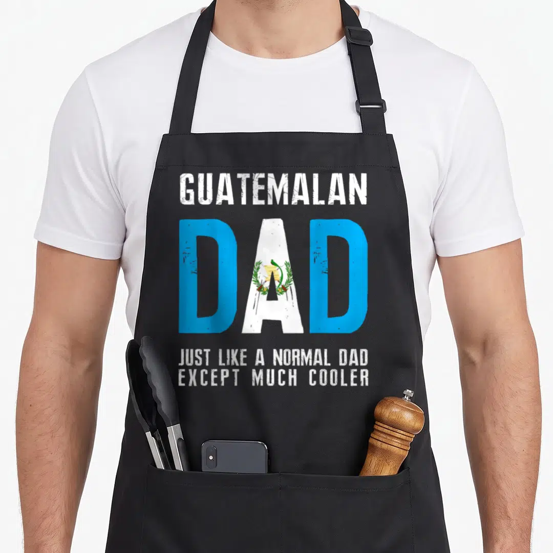Normal guatemalan aprons - Guatemalan Dad text with flag fill in blue white green and distressed finish — shown on a black cotton canvas apron against a white background