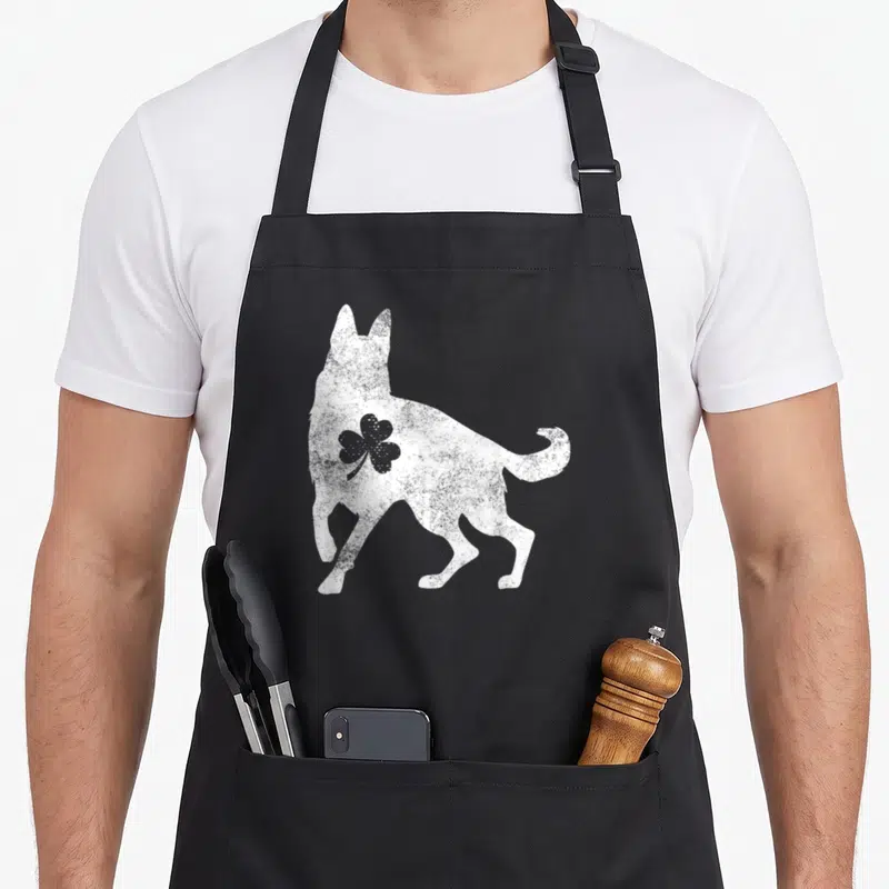 German st patrick day aprons - White distressed dog silhouette with grey shamrock on shoulder — shown on a black cotton canvas apron against a white background