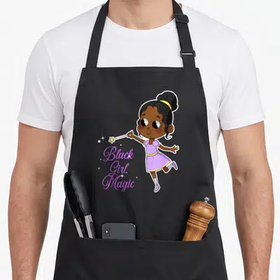 Pride magic apron - Cartoon girl holding wand beside Black Girl Magic script text with sparkles — shown on a black cotton canvas apron against a white background