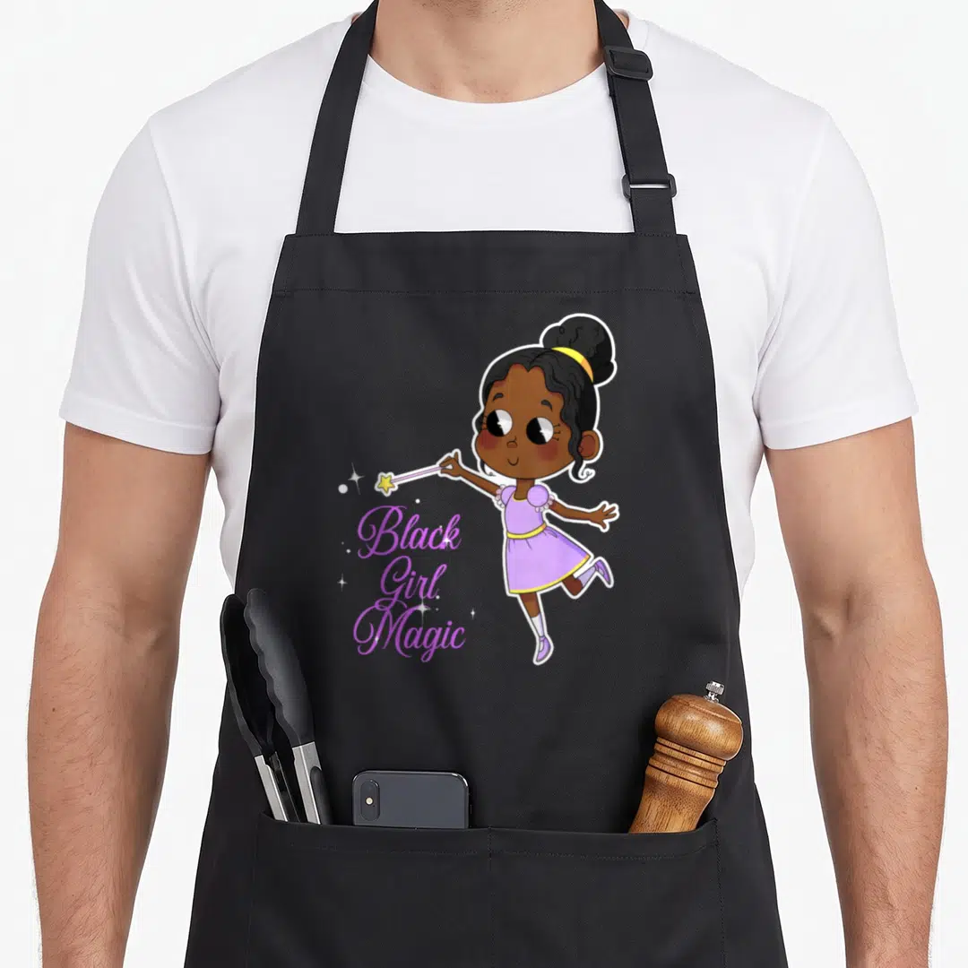 Pride magic apron - Cartoon girl holding wand beside Black Girl Magic script text with sparkles — shown on a black cotton canvas apron against a white background