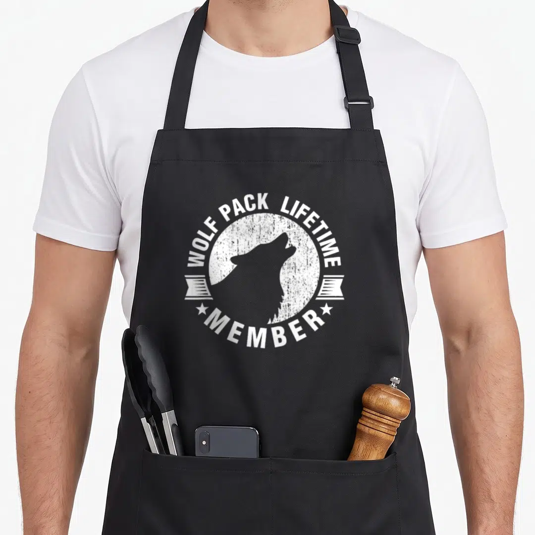 Lifetime distressed apron - Wolf pack lifetime member badge with grey wolf silhouette inside distressed white circle — shown on a black cotton canvas apron against a white background