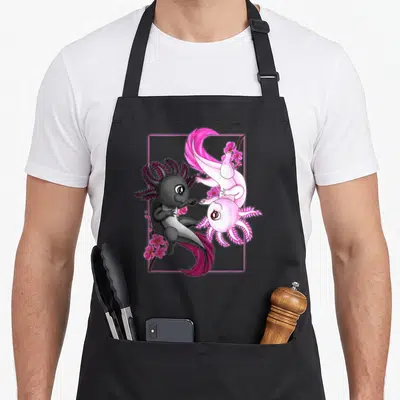 Axolotl cherry apron - Two curled axolotls and pink cherry blossoms inside a glowing pink square frame — shown on a black cotton canvas apron against a white background