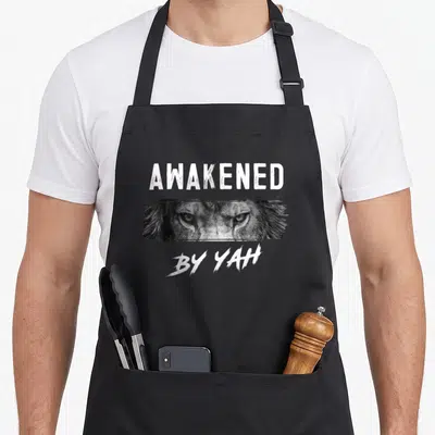 Awakened jewish apron - AWAKENED BY YAH text above cropped lion eyes in grayscale — shown on a black cotton canvas apron against a white background
