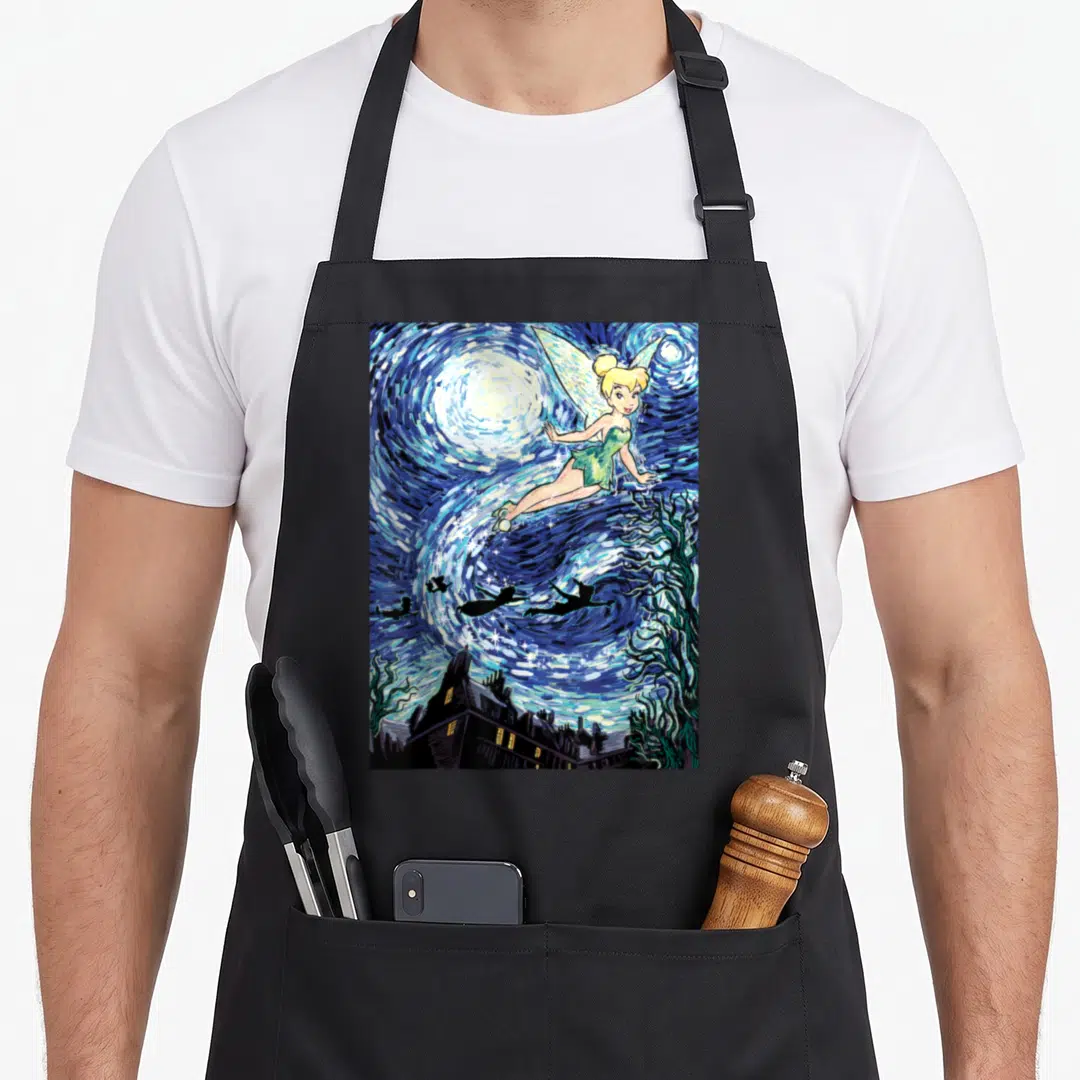 Peter starry night apron - Tinker Bell flying in a swirling blue starry sky above a dark village skyline in watercolor — shown on a black cotton canvas apron against a white background