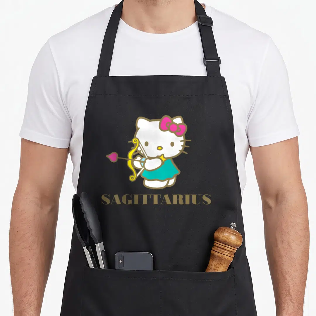 Cute sagittarius zodiac aprons - Hello Kitty holding a bow and arrow with SAGITTARIUS text below in white pink gold teal — shown on a black cotton canvas apron against a white background