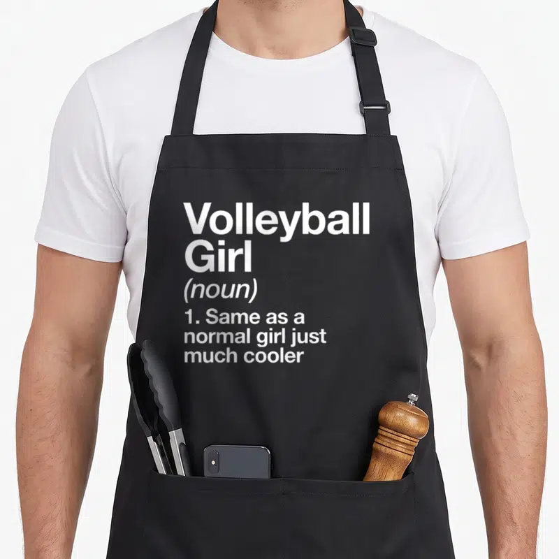 Volleyball sassy apron - White stacked text reading Volleyball Girl noun same as normal girl just much cooler — shown on a black cotton canvas apron against a white background