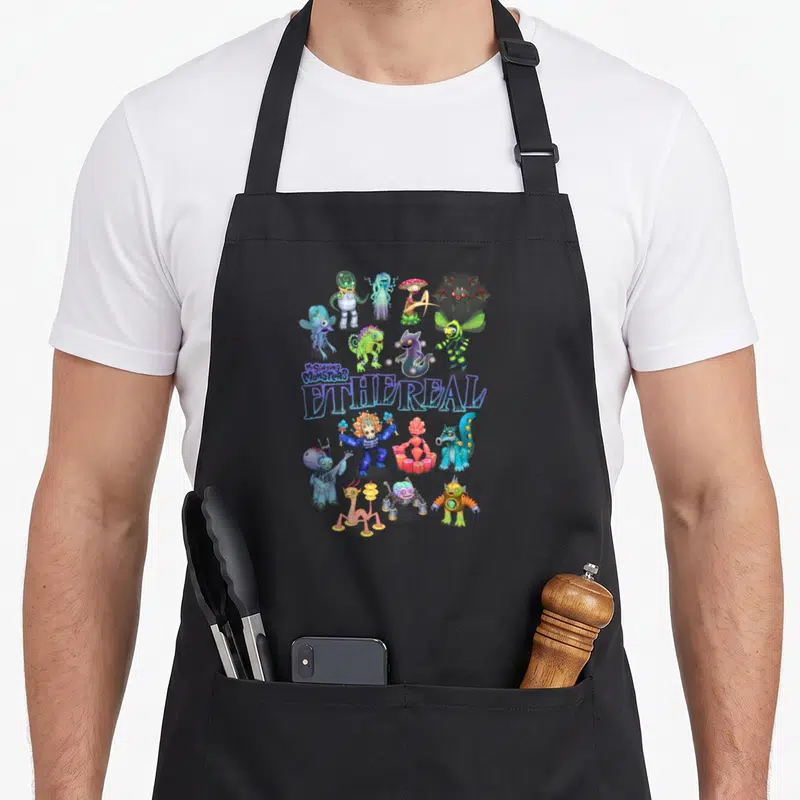 Ethereal boy monster apron - Cluster of cartoon monsters surrounding stacked My Singing Monsters ETHEREAL text in blue — shown on a black cotton canvas apron against a white background