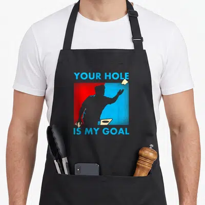 Goal hole apron - Grey disc golfer silhouette over red and blue split background with YOUR HOLE IS MY GOAL text — shown on a black cotton canvas apron against a white background
